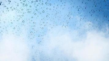 gotas de chuva na janela de vidro azul com fundo de nevoeiro de movimento. video