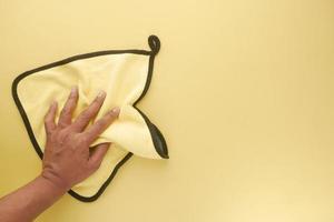 top view of person hand cleaning table with yellow color cloth photo