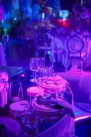 Table setup in purple light. Ready to event. Shallow dof photo