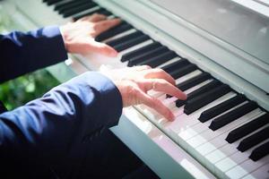 closeup mano hombre tocando el piano. instrumento de música clásica. tono de color desvanecido. foto