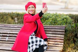 Cheerful woman taking selfie in park photo