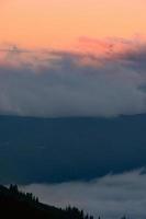 Dawn in the mountains, clouds covered the slopes of the Carpathians. photo