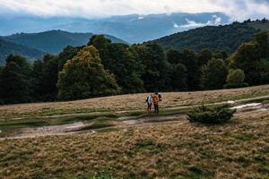 Tourists walk through the Ukrainian Carpathians, tourists carry heavy backpacks on their backs. photo