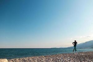 running on the sand, a woman runs along the beach photo