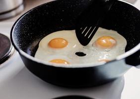 Person preparing fried eggs photo