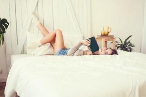 mujer bonita disfrutando leyendo un libro en casa