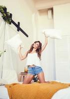 Young attractive woman, cheerful brunette with pillows