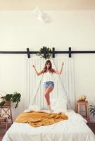 Portrait of a joyful smiling girl throws a pillow photo