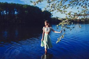 niña se encuentra entre los árboles en flor foto