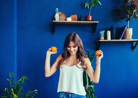 woman on vibrant blue background holds orange
