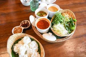 Thai rice vermicelli noodle with soup curry sauce and fresh vegetable set - Thai traditional menu photo