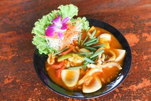 Stir fried squid with salted egg yolk on white dish on table background, curry squid photo