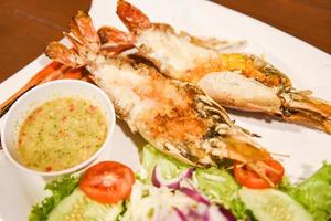 Grilled shrimp cut half with fresh vegetable and seafood sauce, Giant river prawn shrimp grilled serve on white plate photo