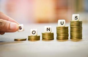 Yearly Bonus concept hand holding words of bonus on stack coins staircase photo