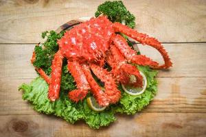 Alaskan King Crab Cooked steam or Boiled seafood and lettuce salad vegetable with wooden background - red crab hokkaido photo
