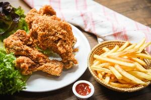 french fries basket ketchup on wooden dining table background and fried chicken crispy and salad lettuce photo