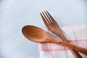 utensilios de cocina de cuchara y tenedor de madera colocados en mantelería en la mesa de comedor - cero desperdicio use menos concepto de plástico foto