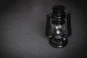 lámpara de aceite por la noche sobre un fondo oscuro - farol viejo vintage negro clásico foto