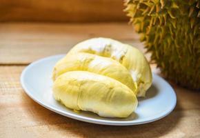 Cáscara de durián fresco verano de frutas tropicales en plato blanco sobre fondo de madera foto