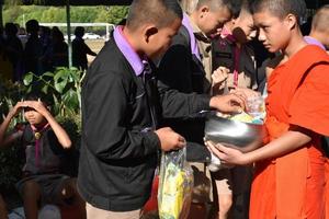 Buddhist monks and novices are receiving foods from Thai students at school in special occasion, father's day.