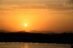 beautiful warm sunset with mountains and sea photo