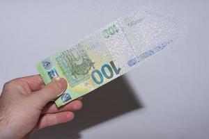 single euro bank note held in one hand decomposes and dissolves with gray photo
