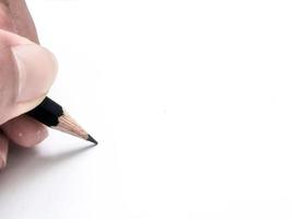 mano sosteniendo un lápiz negro listo para escribir algo en papel foto