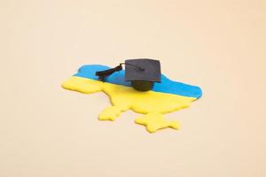 Plasticine map of Ukraine with a graduate hat. Education in Ukraine concept photo