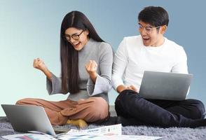 Excited lottery winning person. Cheerful fortune woman shocked with money received from online lotto jackpot. Lucky couple have fun laughing at wealth opportunity of investment success online gambling photo