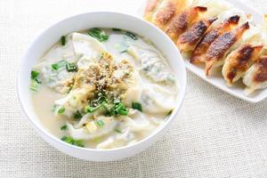 sopa wonton con cebolleta servida en un tazón blanco, enfoque selectivo foto