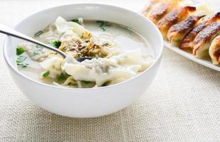 sopa wonton con cebolleta servida en un tazón blanco, enfoque selectivo foto