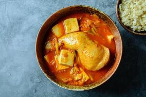 Korean traditional Kimchi soup with chicken and soft tofu photo