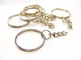 anillo de metal y cadena para llave y baratija sobre fondo blanco. foto