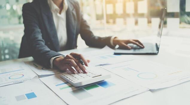 Accountant working on desk using calculator for calculate finance report in office. photo