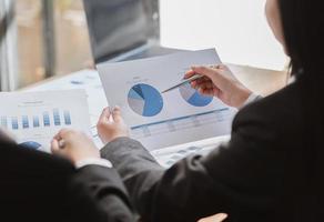 empresarios discutiendo las tablas y gráficos que muestran los resultados de su exitoso trabajo en equipo foto