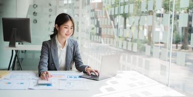 Asian woman working in the office using a laptop. copy space. photo