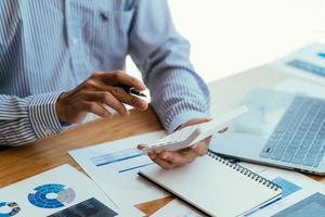 Business accounting concept, Business man using calculator with computer laptop, budget and loan paper in office. photo