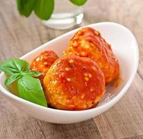 meatballs in tomato sauce, decorated with leaves of basil photo