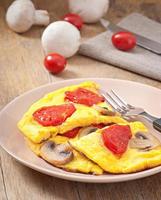 Delicious omelet with tomatoes and mushrooms for breakfast photo