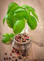 mixture of pepper peas in an old bowl and basil leaves photo