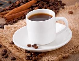 vista de cerca de una taza de café, azúcar moreno y granos de café foto