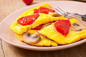 Delicious omelet with tomatoes and mushrooms for breakfast photo