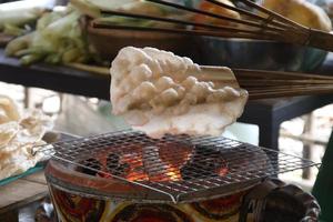 una galleta de arroz indígena sobre bambú se asa a la parrilla sobre la estufa. foto