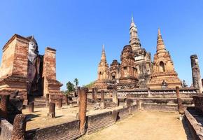 estatua de buda de pie en wat maha that, parque histórico de shukhothai, tailandia foto