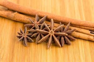 Anise stars and cinnamon stick on wooden board photo