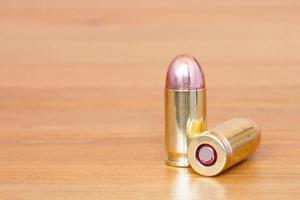 9 mm or .357 bullet on wooden background photo