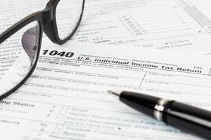 formulario de impuestos con gafas y bolígrafo foto