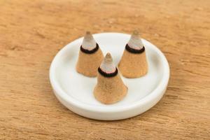 Burning incense cone on plate photo