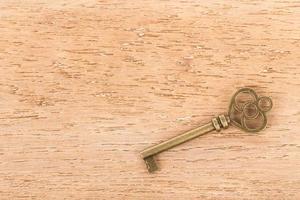 Antique key on wooden background photo