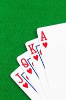 Royal flush poker playing cards on green felt background photo